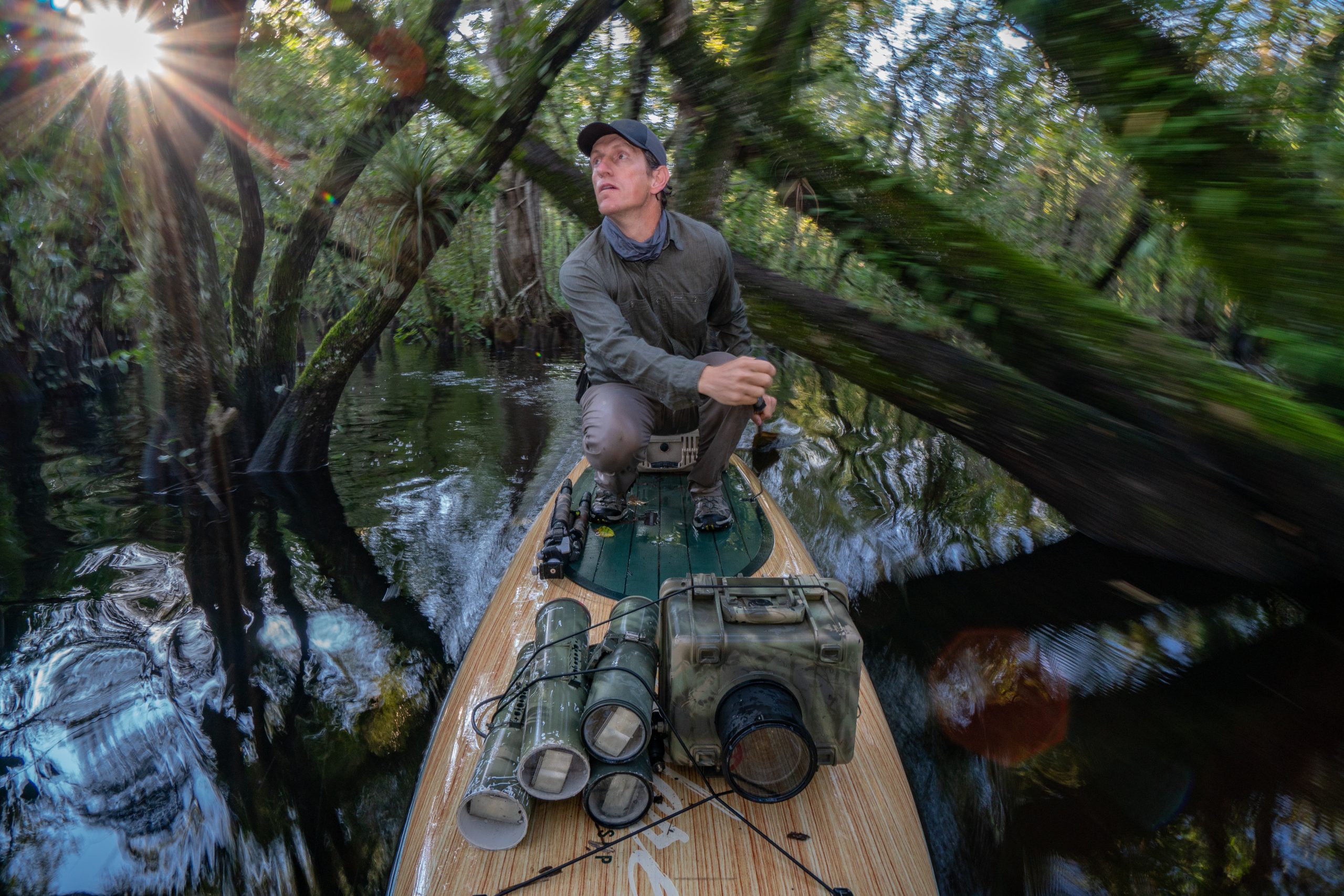 Carlton Ward Jr. paddles into a remote corner of the Fakahatchee Strand to set up a camera-trap system. During the summers of 2016, 2017, and 2018, Ward racked up 5,000 camera trap hours in his effort to capture the first photograph of a ghost orchid being pollinated. Self-portrait by Carlton Ward Jr.