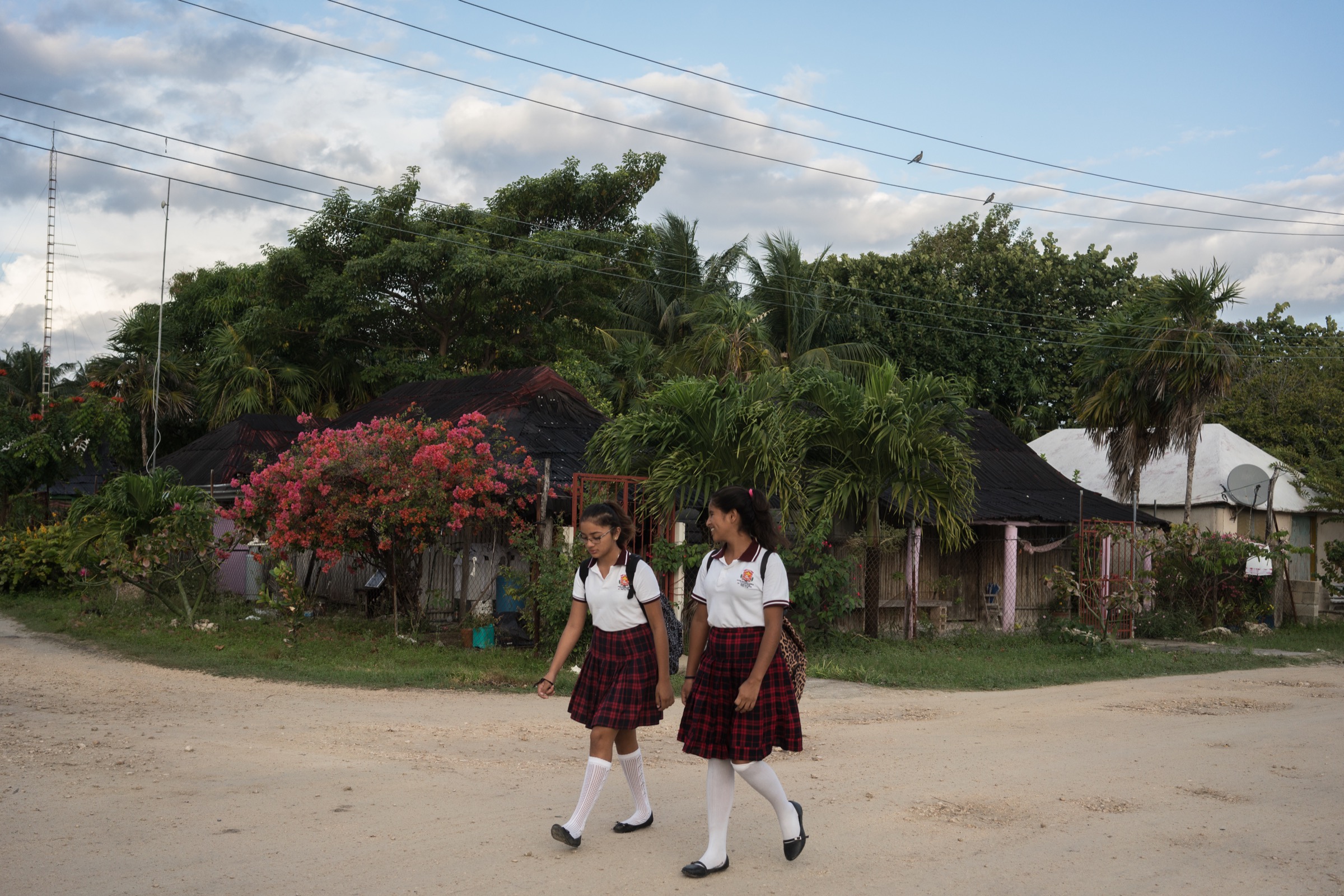 Two girls walk to school in Punta Allen, Mexico, a town that has prospered because of its successful lobster fishery. Photograph by Dominic Bracco II
