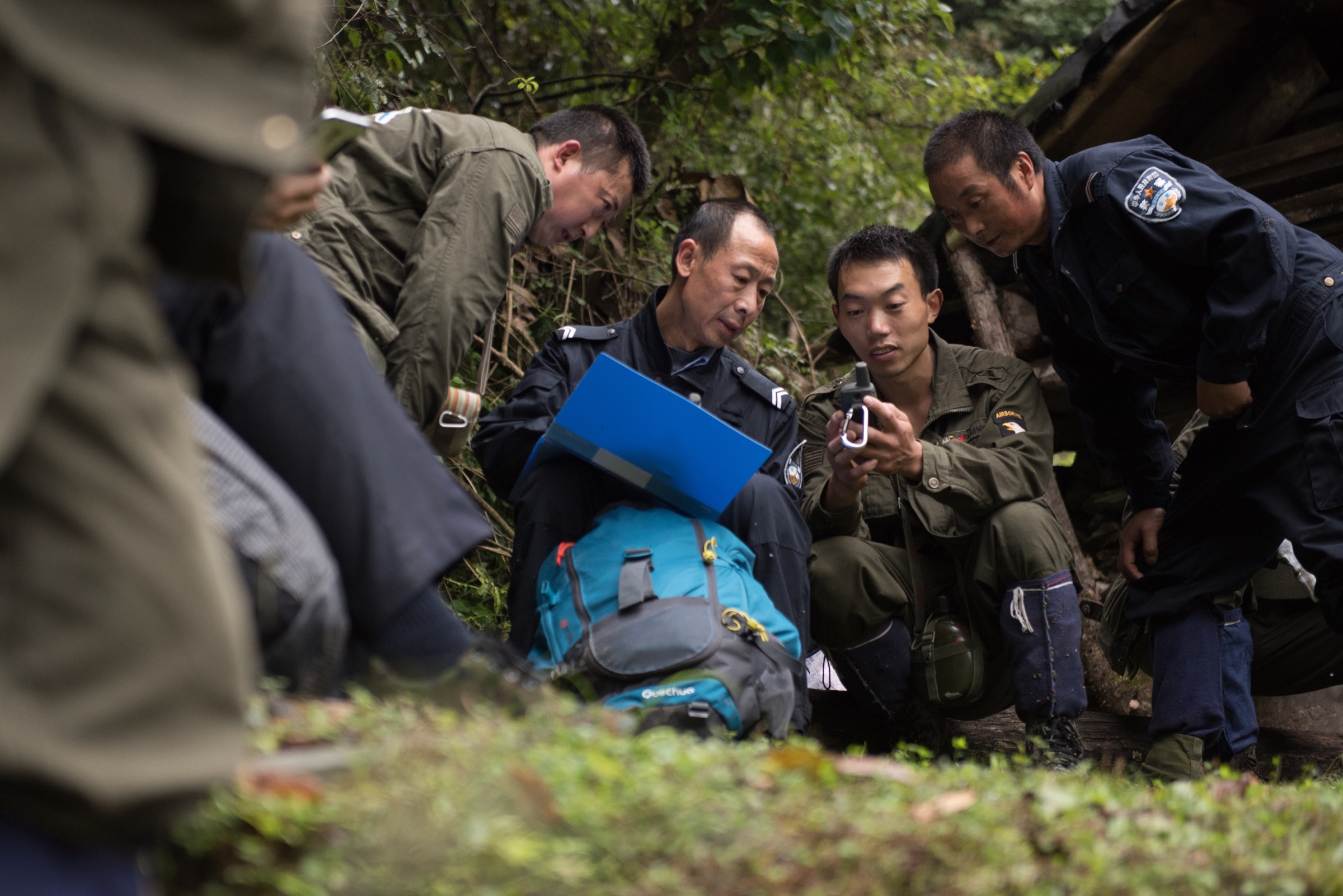 Meng Ji checks GPS coordinates of their route with other patrol members and two local Sichuan government forestry department officers. Photograph by Kyle Obermann