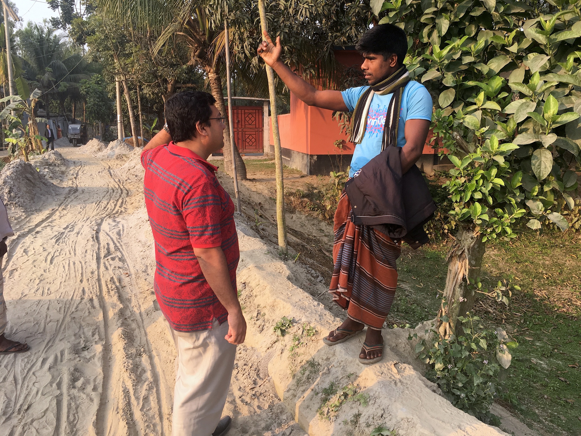 Physician Hossain M. S. Sazzad from ICDDR,B asks a resident of the village of Mohonpur for directions to the home of the local collector and seller of date palm sap. Photograph by Steven Bedard