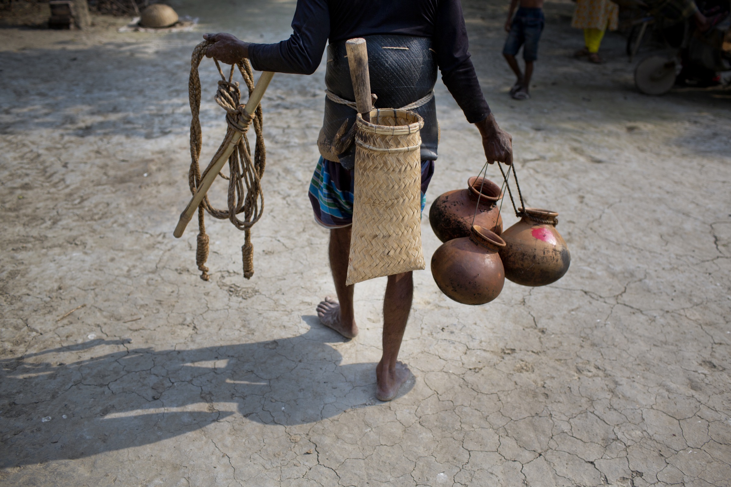 With his tools of the trade, a gachhi goes off to climb and tap date palm trees for the sap that he hopes to sell to excited locals the very next day. Photograph by A.M. Ahad