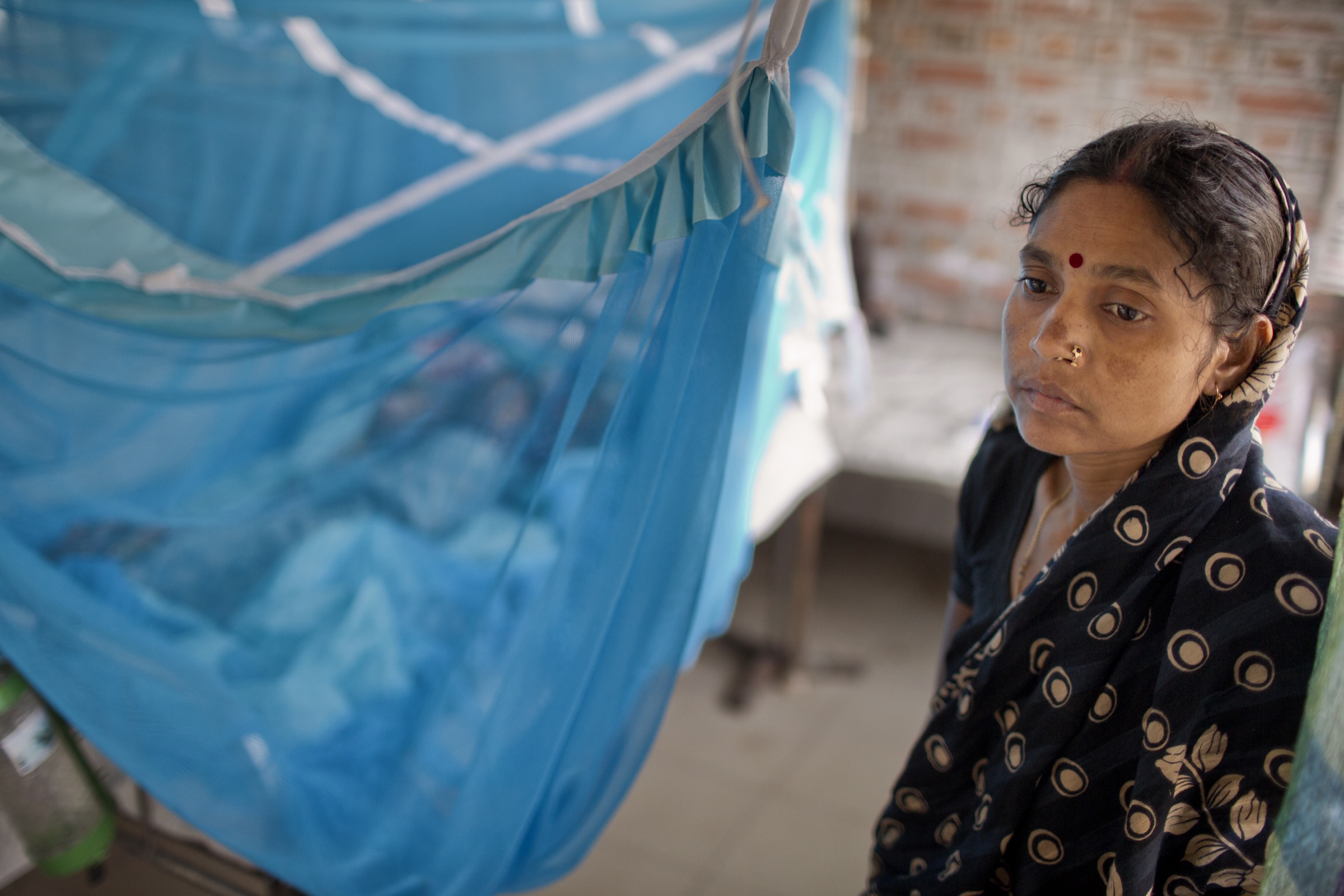 A young mother stands watch over her son who was admitted at Faridpur Medical College Hospital with symptoms of encephalitis. Diagnostic tests later determined that Nipah virus was not the cause of his illness. Photograph by A.M. Ahad