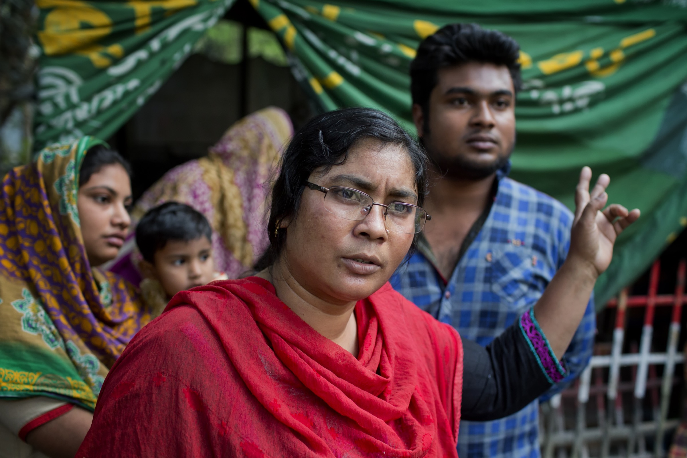 A woman discusses the 2011 Nipah outbreak in Faridpur that took seven members of her family. She and her son (in blue) were also infected but survived. Photograph by A.M. Ahad