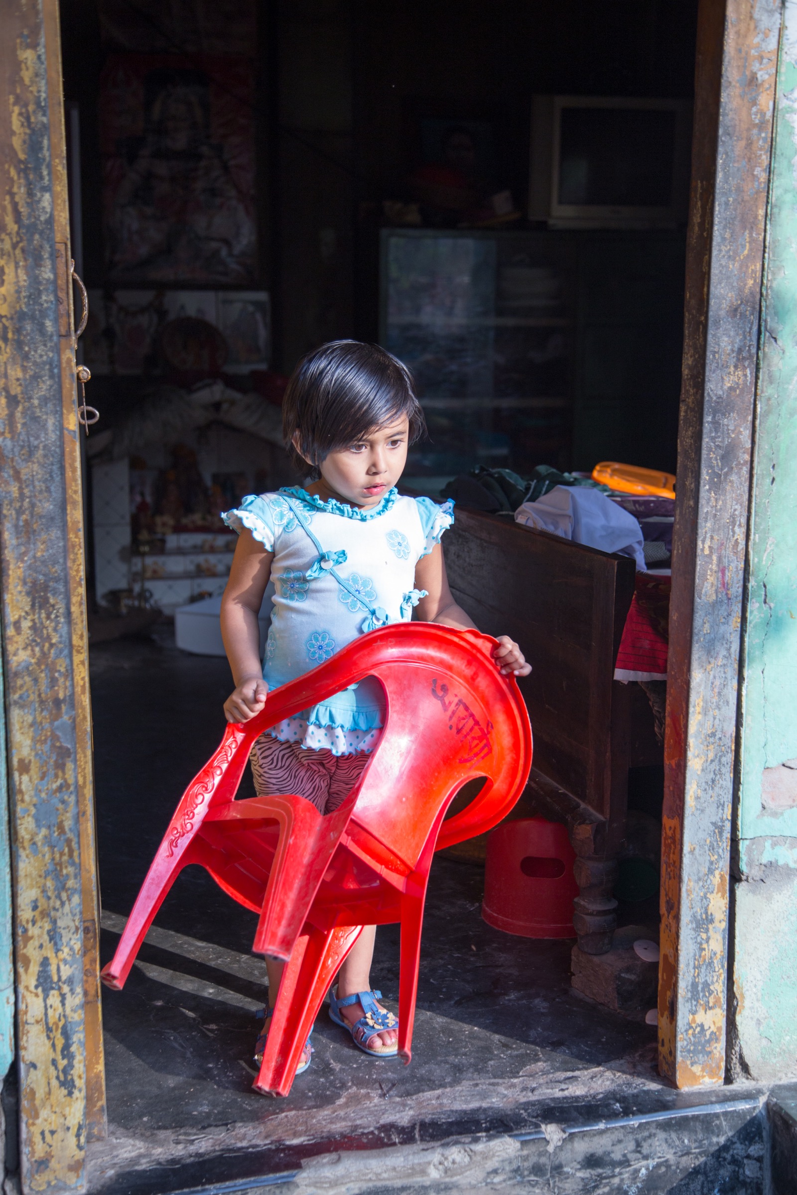 A young girl has already started practicing the customary greeting in northern Bangladesh, offering visitors with a comfortable place to sit. Photograph by Steven Bedard