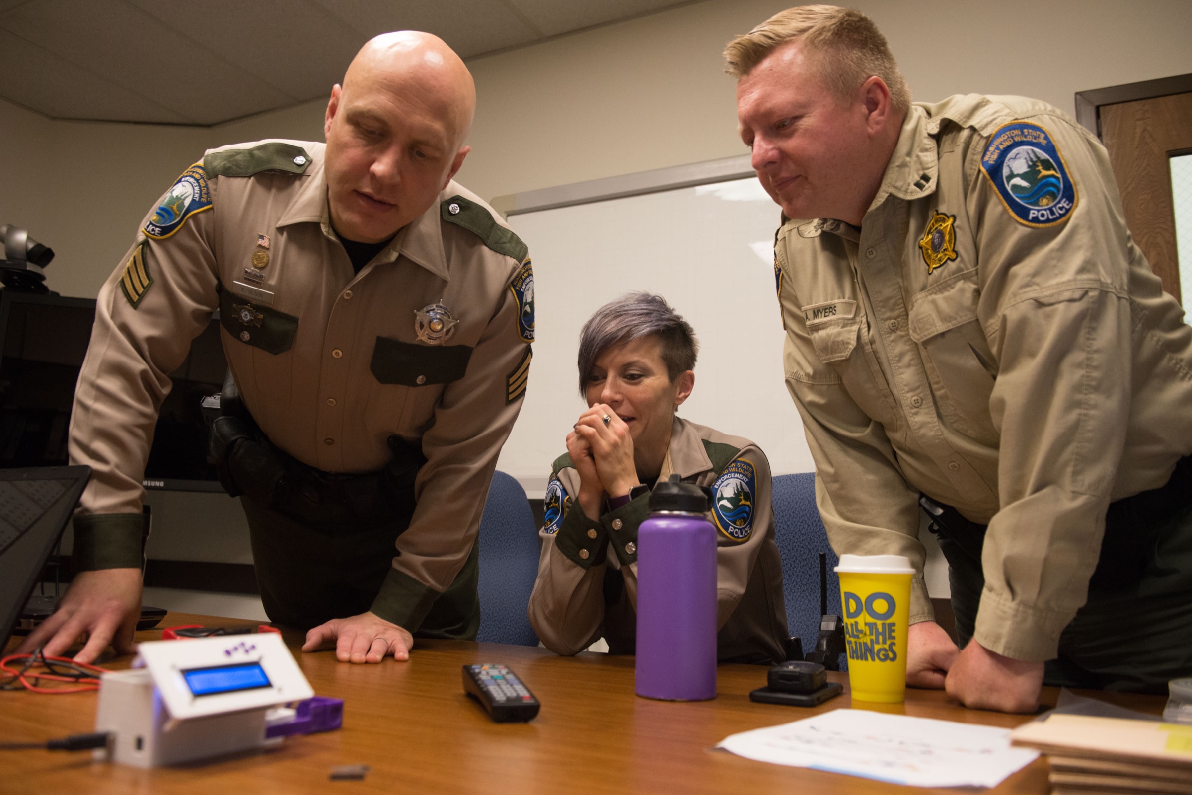 Sergeant Erik Olson, Officer Tylar Stephenson and Captain Alan Myers inspect the DNA barcode scanner during a test run. Photograph by Daniel Berman