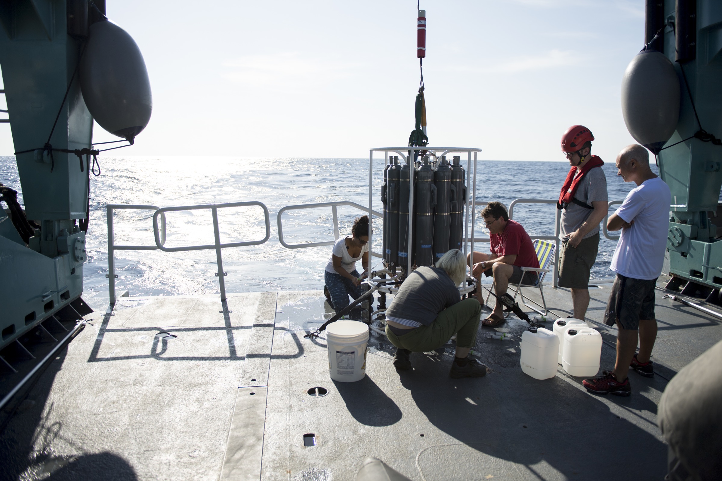 Scientists pull ocean water from the large CTD sampler into smaller syringes in preparation for analysis of the make-up of water deep below the surface. Photograph by Novus Select