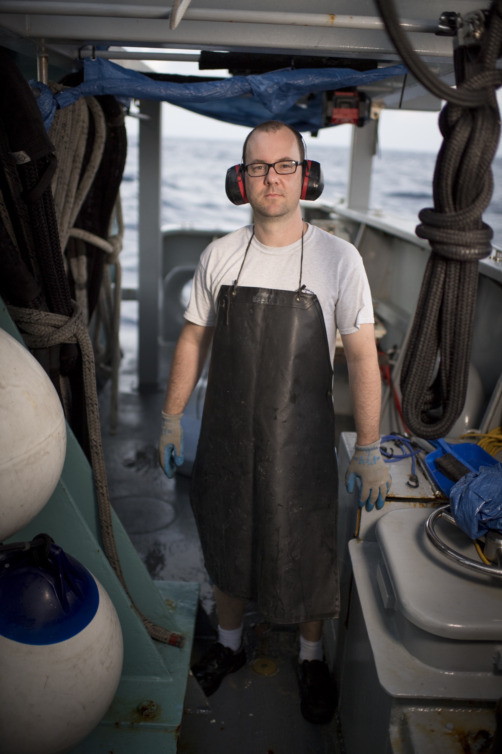 Frieder Klein, a marine geologist from Woods Hole Oceanographic Institution and the leader of the expedition, takes a break from cutting rock samples collected from the deep ocean below Saint Peter and Saint Paul Archipelago. Photograph by Novus Select
