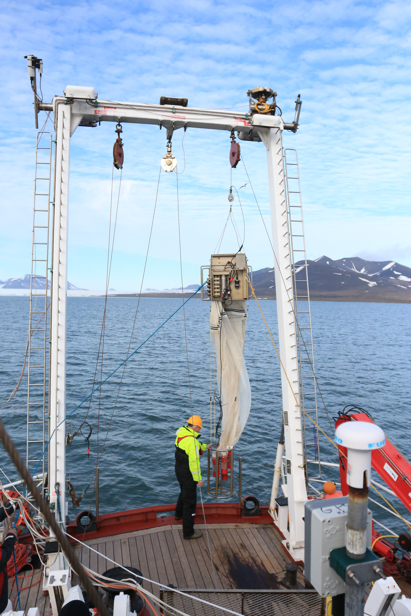 Scientists and crew lower the multinet into the ocean. The device opens and closes net bags at various depths so scientists can capture and study the organisms that live in different parts of the water column. Photograph by Hannah Hoag
