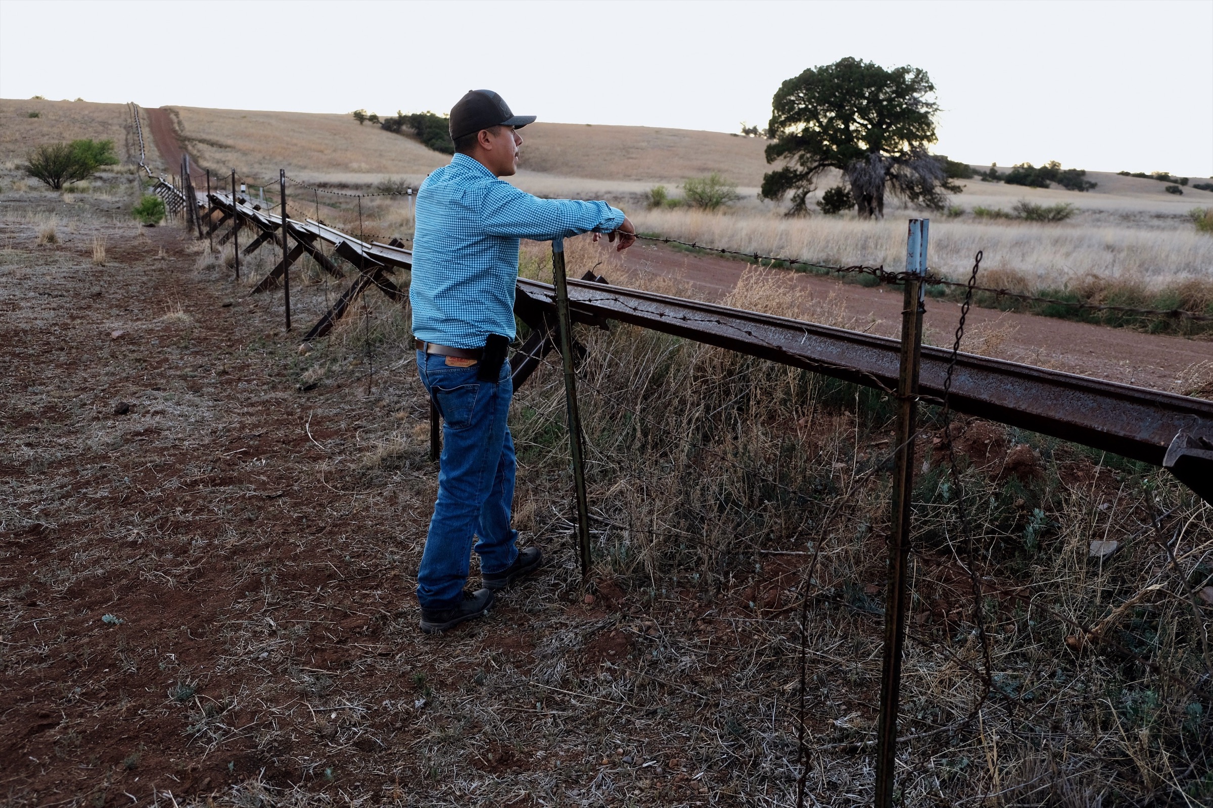 Daniel Toyo, an agricultural technician for the environmental non-profit Naturalia looks into Arizona across a fence that marks the northern boundary of the group’s Rancho Los Fresnos property. Photograph by Julian Smith