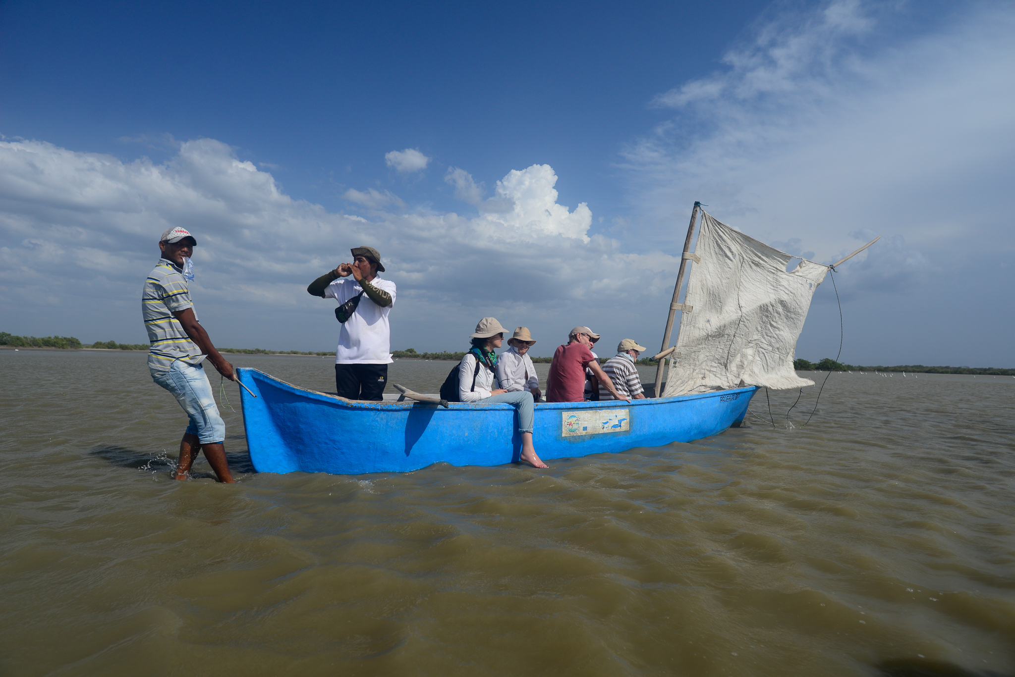 One Wayuú guide shouts instructions as another pulls a canoe of French tourists to shore in Los Flamencos Wildlife Reserve. Photograph by Lindsay Fendt