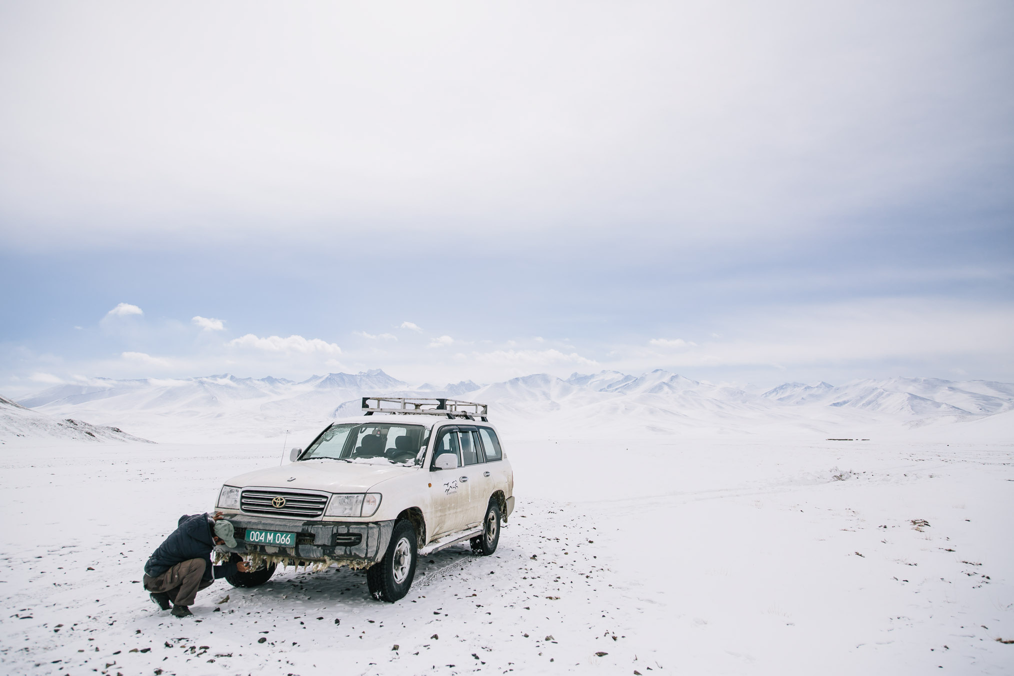 Jura, a biologist for the conservation organization Panthera navigates a Land Cruiser through deep snow, roughly following a two-track off the main highway. Photograph by Joel Caldwell