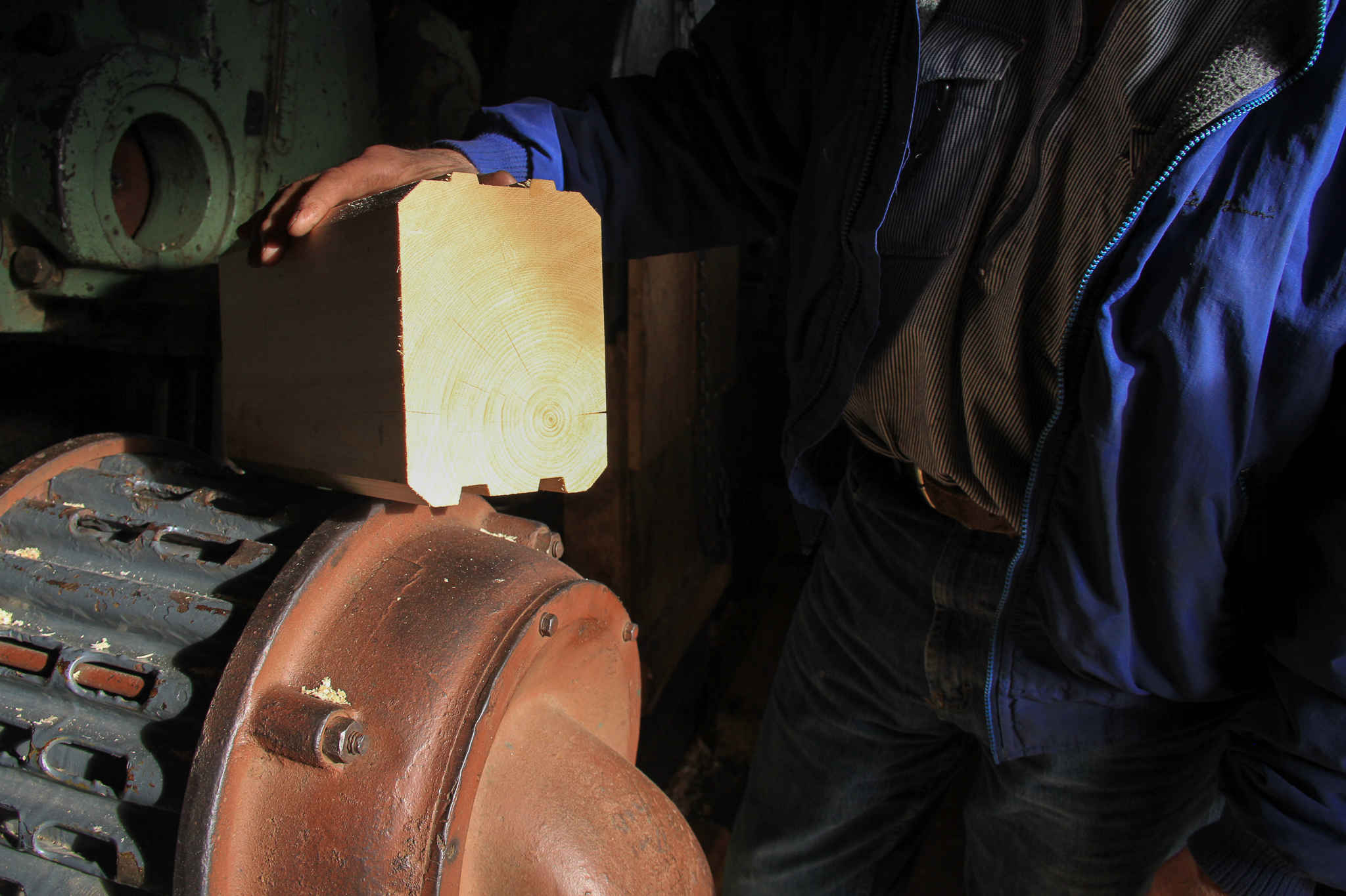 Icy Straits Lumber owner Wes Tyler shows off a log cross-section from a cabin kit. Cabins might be one value-added market for young growth wood in Southeast Alaska.