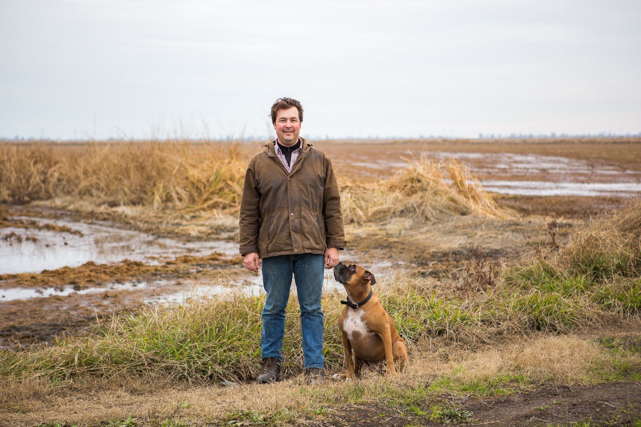 Dan Anderson, a fourth-generation rice farmer, stands next to his search-and-rescue dog, Cooper, in Richvale, California.