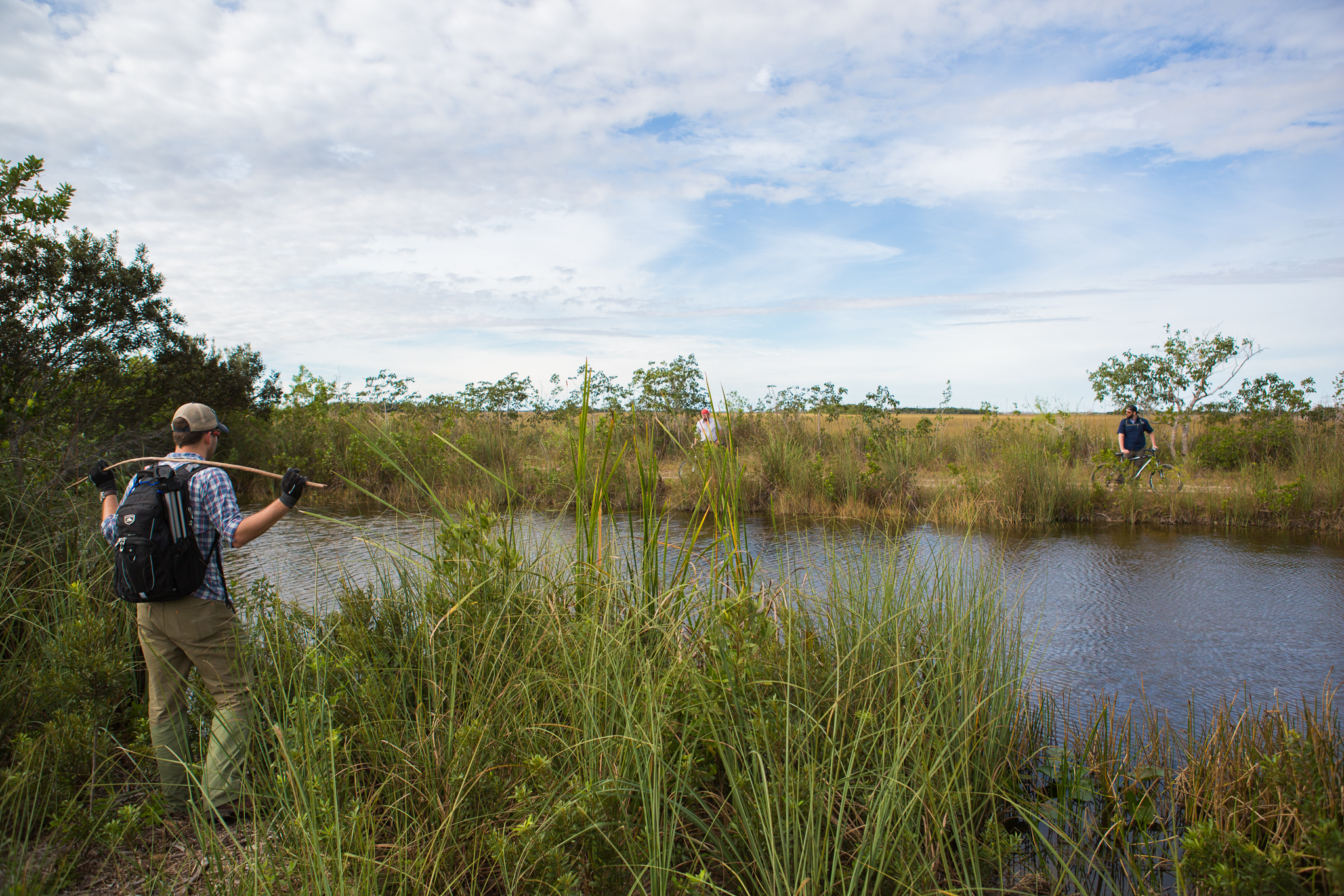 Steven Neslage calls across to Sean Sterrett and Sean Graham as they search for pythons along canal C-110.