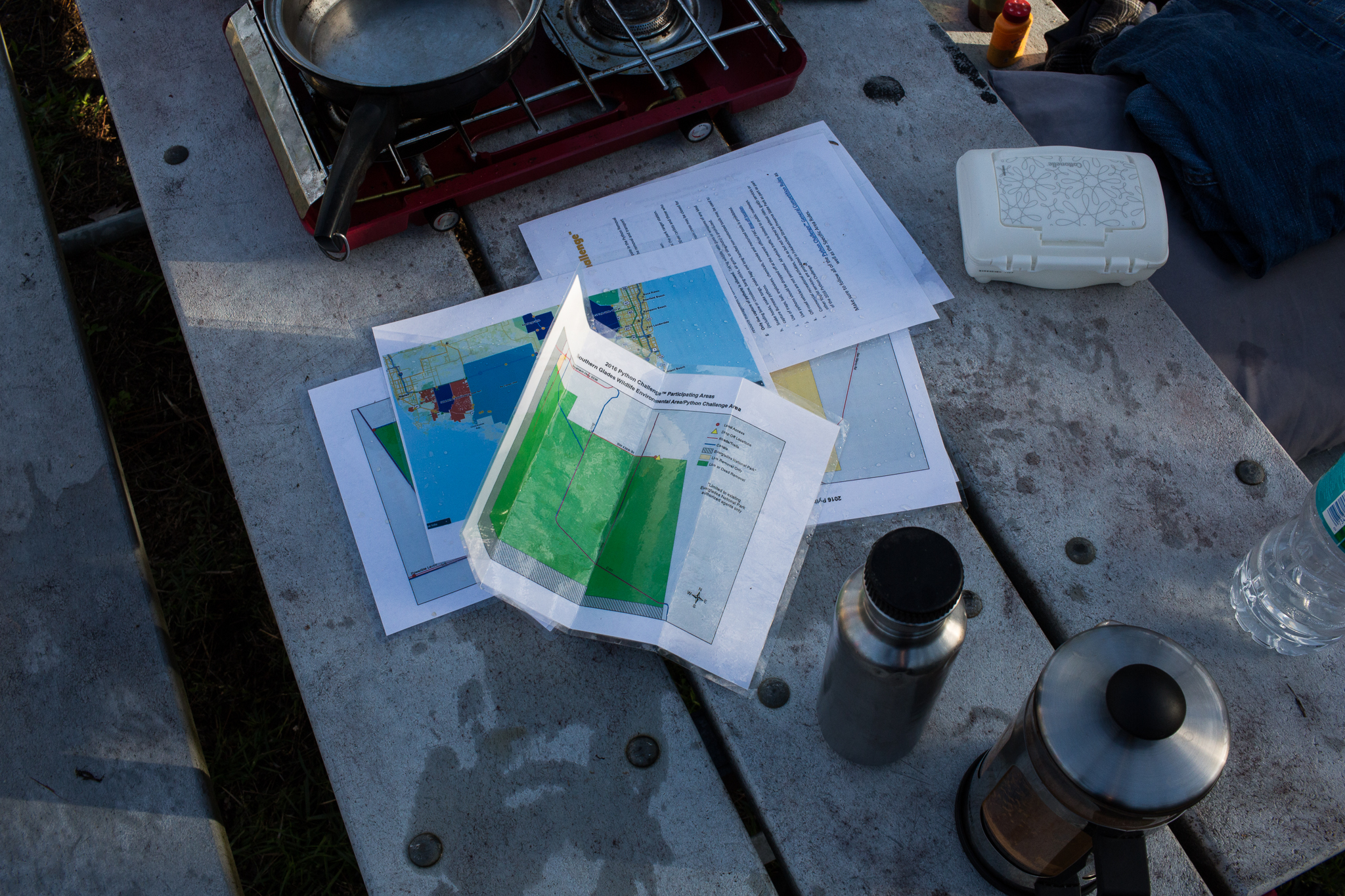 Essential snake-hunting supplies: maps, coffee, and baby wipes for post-capture cleanup