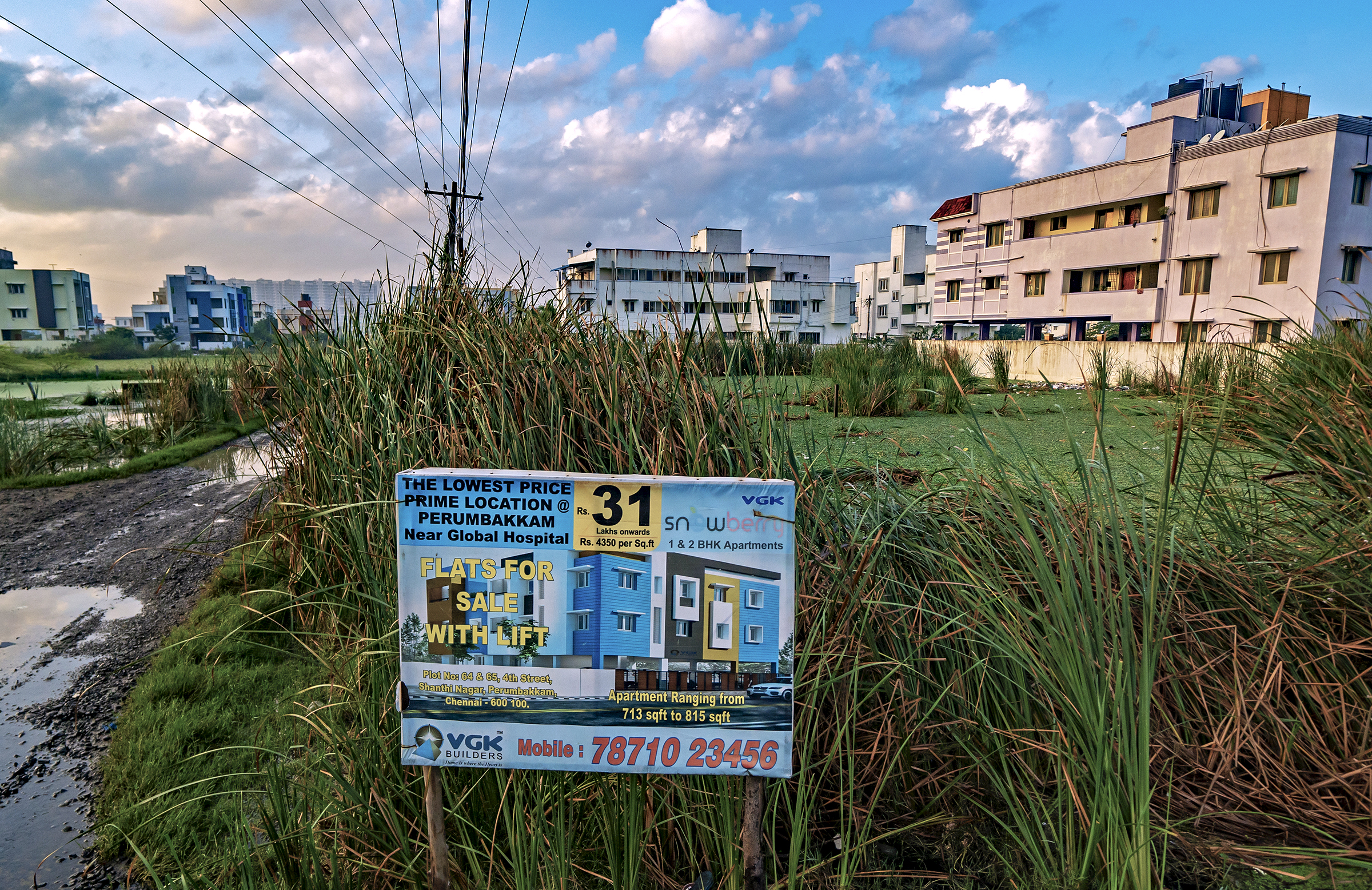 Chennai's marshlands continue to be paved over and sold, despite urban development's impacts on the floods, droughts, and the region's dwindling wetland ecosystems. This sign advertises prime real estate locations at Perumbakken, a once-expansive wetland in Chennai.