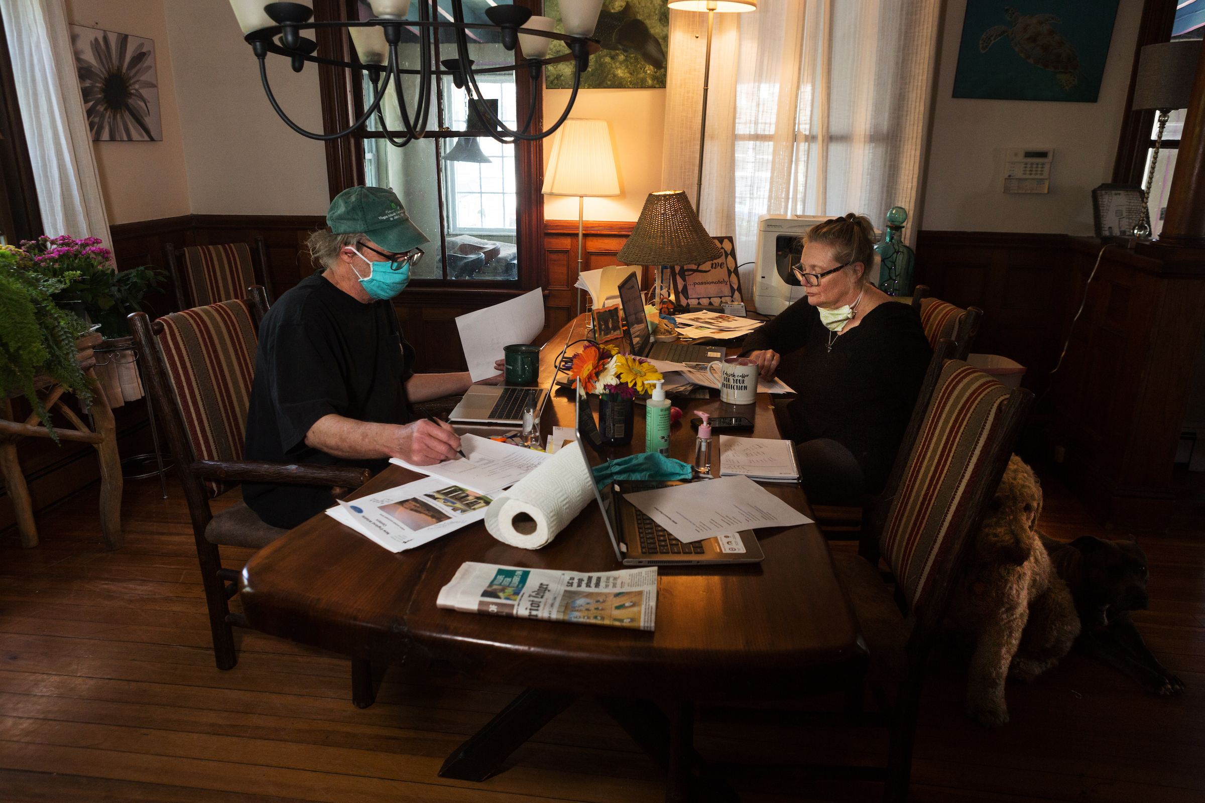 Dr. Greg Mertz (left) of the New England Wildlife Center and Katrina Bergman (right) work at the table in their home in Hull, Massachusetts. Mertz and Bergman are working on a bill that would allow veterinarians and licensed rehabilitators to use telehealth technologies to help diagnose wild animals.