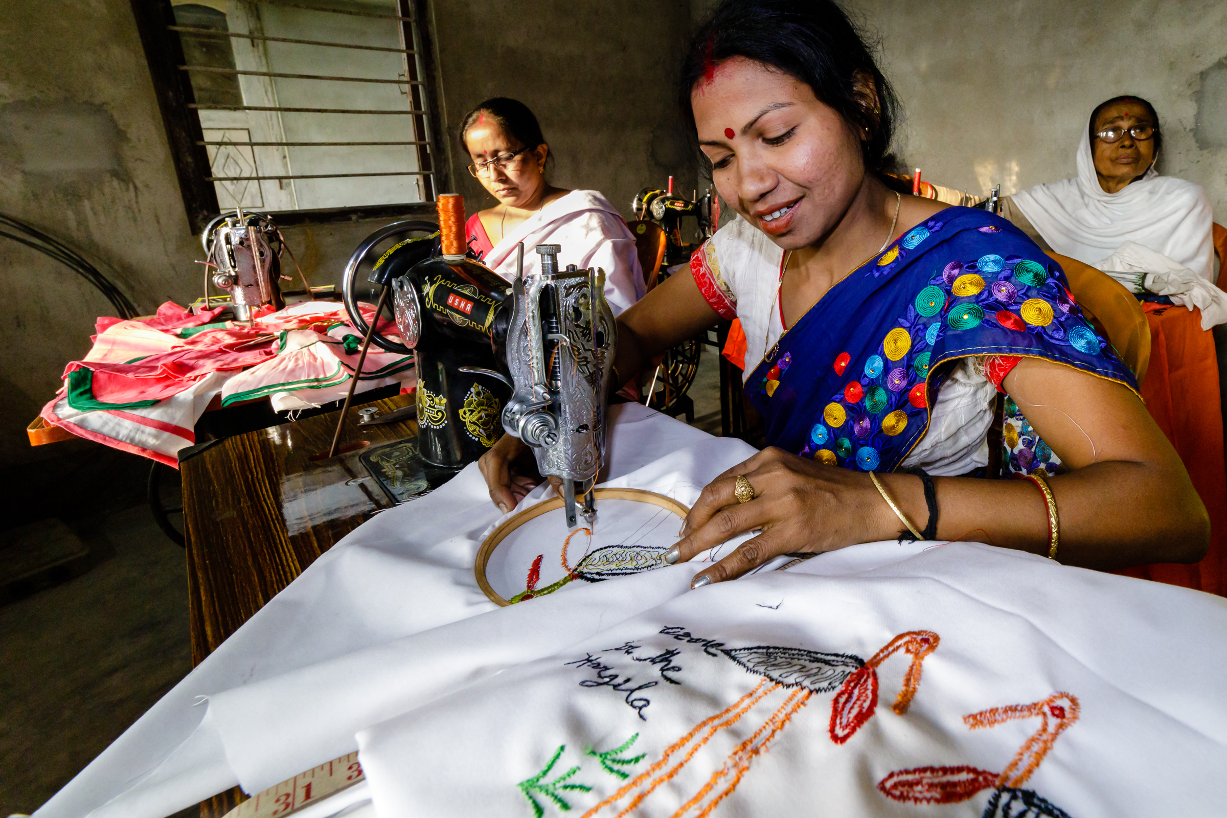 Jonali, a member of the "Hargila Army," is pictured sewing a tote bag with an embroidered greater adjutant motif to help combat plastic bag usage. Members of the Hargila Army take great pride in protecting this endangered species.