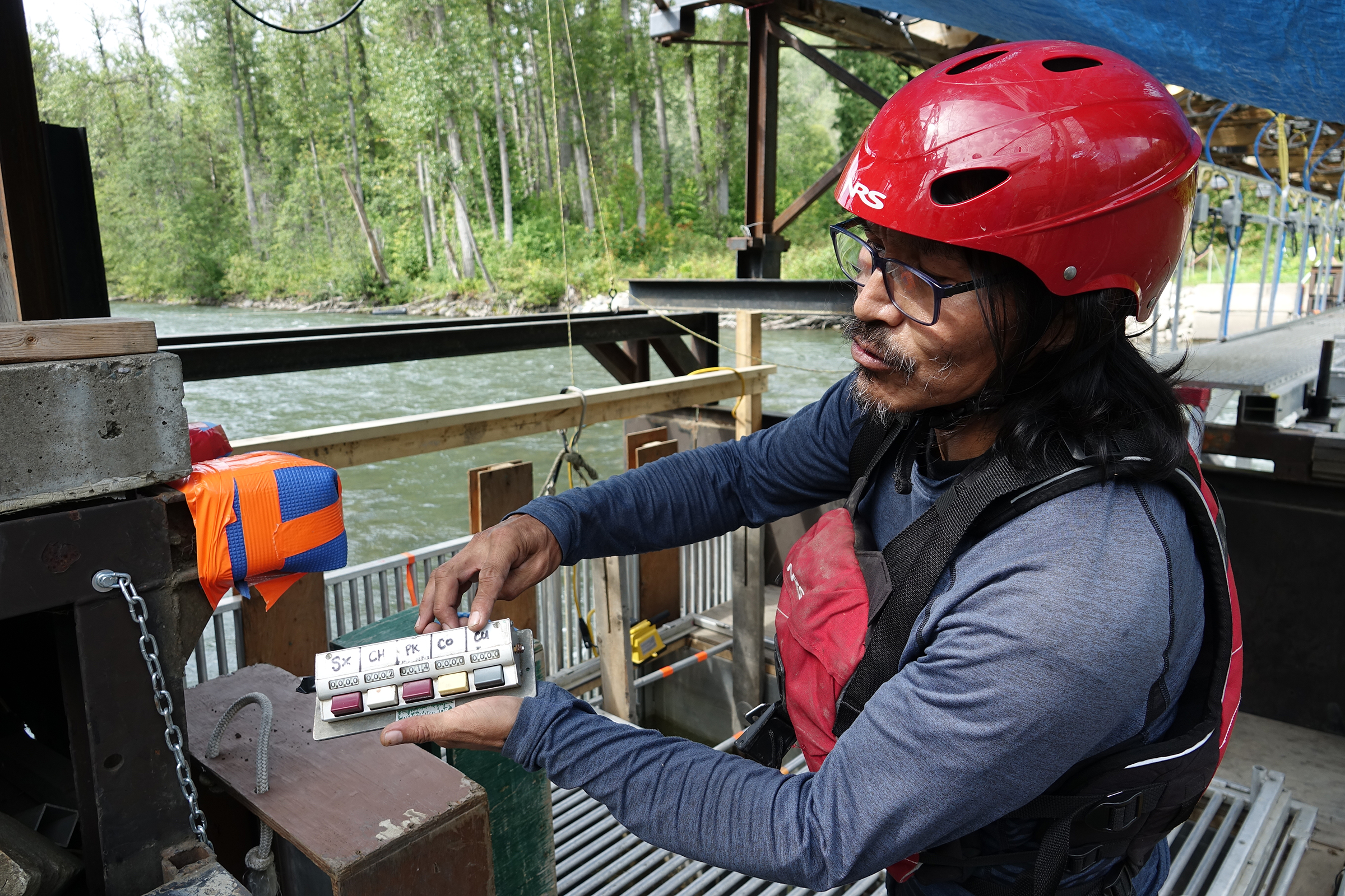 Leslie McLean, a technician at the Kitwanga River Salmon Enumeration Facility, demonstrates the operation of a high-tech fish fence that records the passage of every salmon swimming upstream. The Gitanyow First Nation, in collaboration with the DFO and other partners, has monitored salmon runs here for the past 18 years. Conservation and monitoring work by the Gitanyow aims to rebuild the sockeye population to enable a future harvest, which hasn’t been possible for more than three decades. Photograph by Lesley Evans Ogden