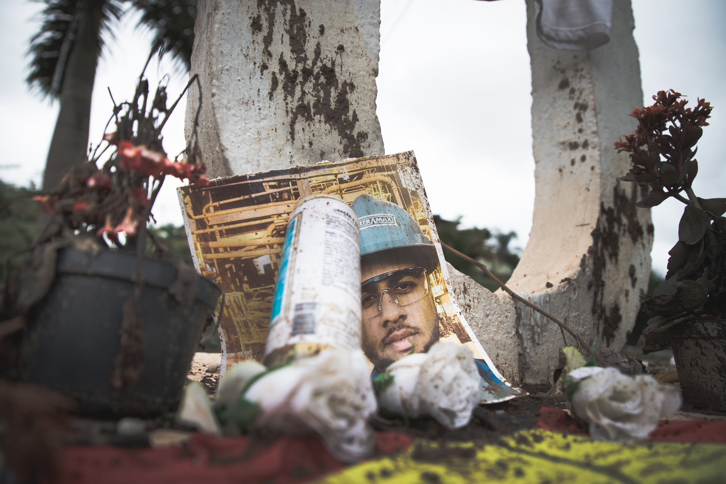 The photograph of a worker killed in the Vale dam collapse of 2019 lies at the base of the of Brumadinho City sign in Minas Gerais. Alongside the photo, a hand-written sign states: "Vale: lucro acima de tudo e lama acima de todos" (Vale: profit above everything and mud above all).