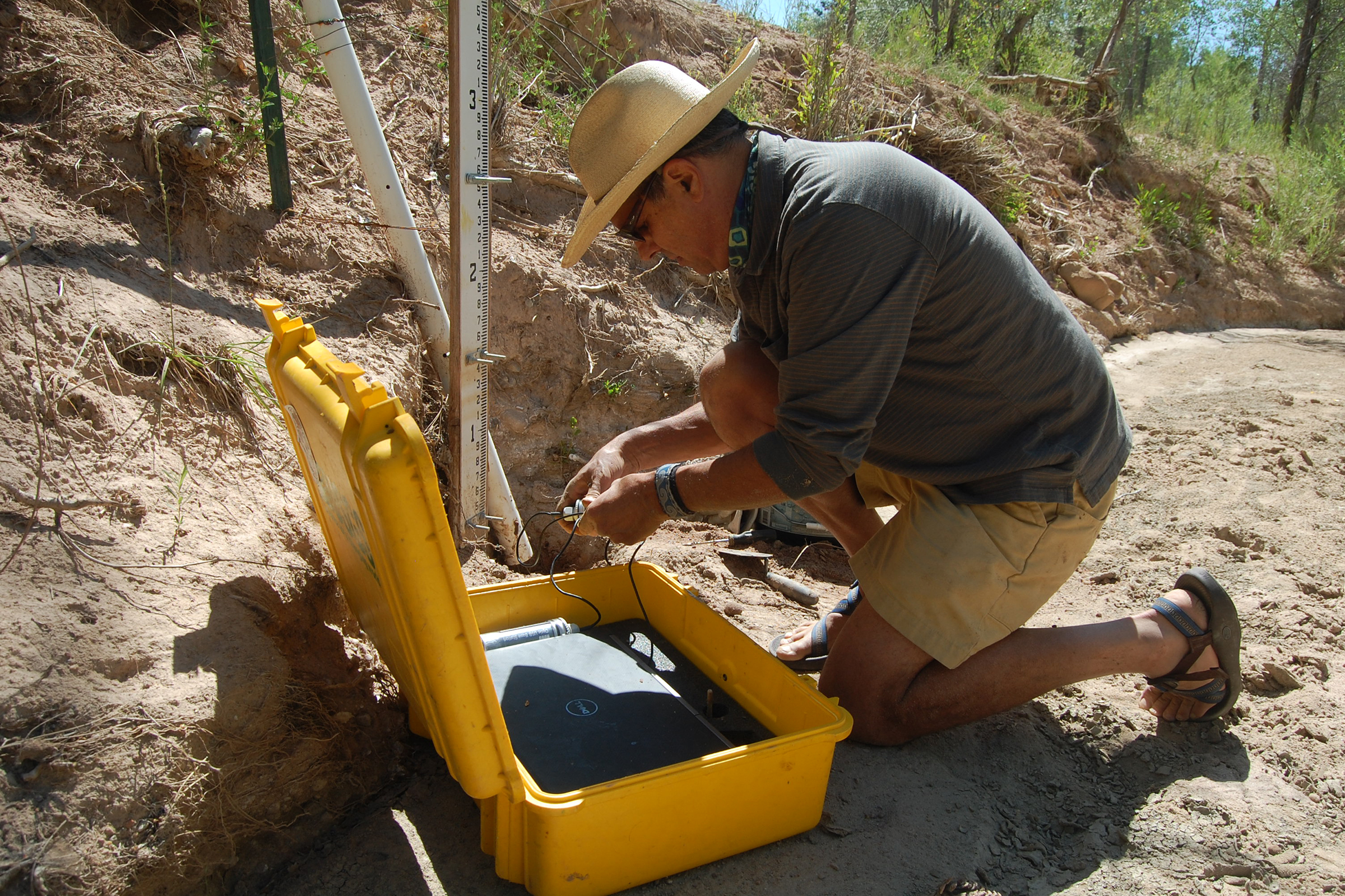 Paul Tashjian, director of freshwater conservation for Audubon Southwest downloads data from a sensor that tracks streamflow in the Rio Gallina.
