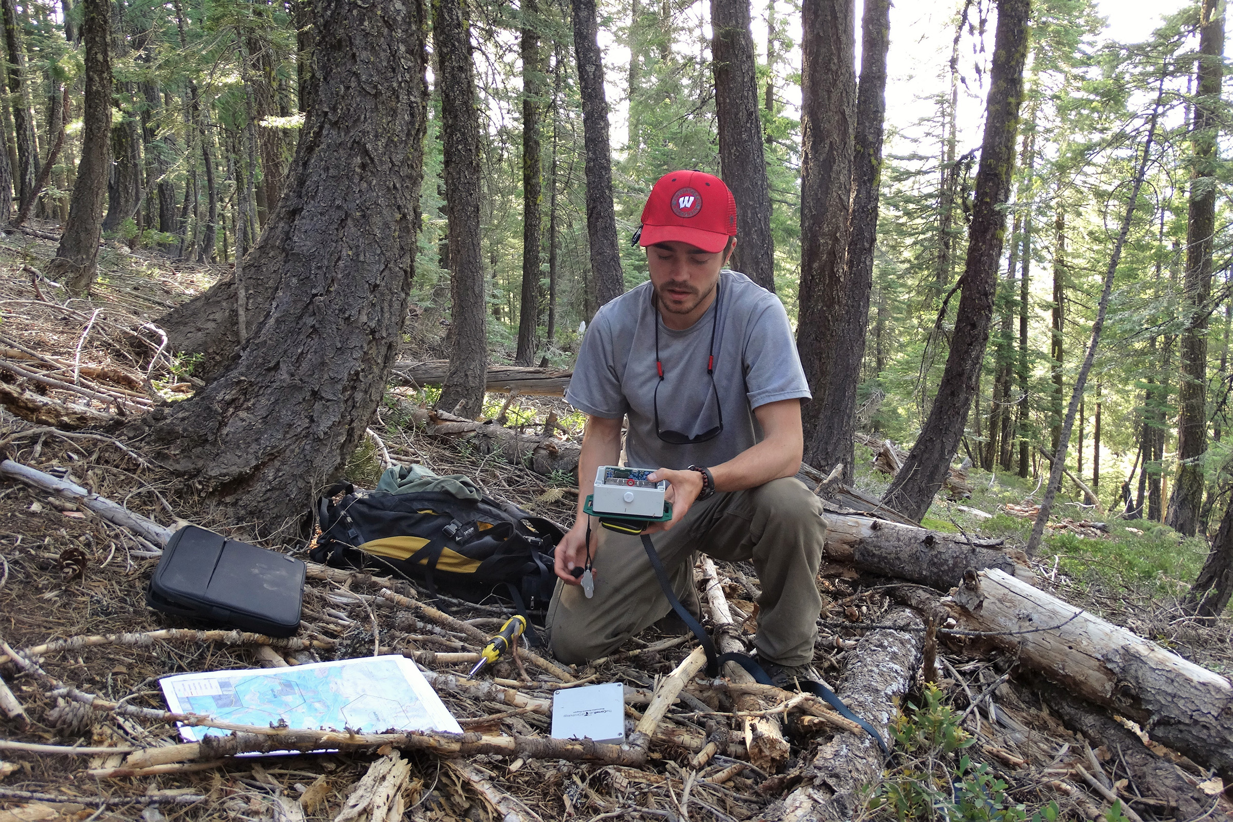 Biologist Connor Wood inspects an autonomous recording unit (ARU) in a Northern California forest as part of a large study on the region’s owls. Photograph by R. J. Gutiérrez
