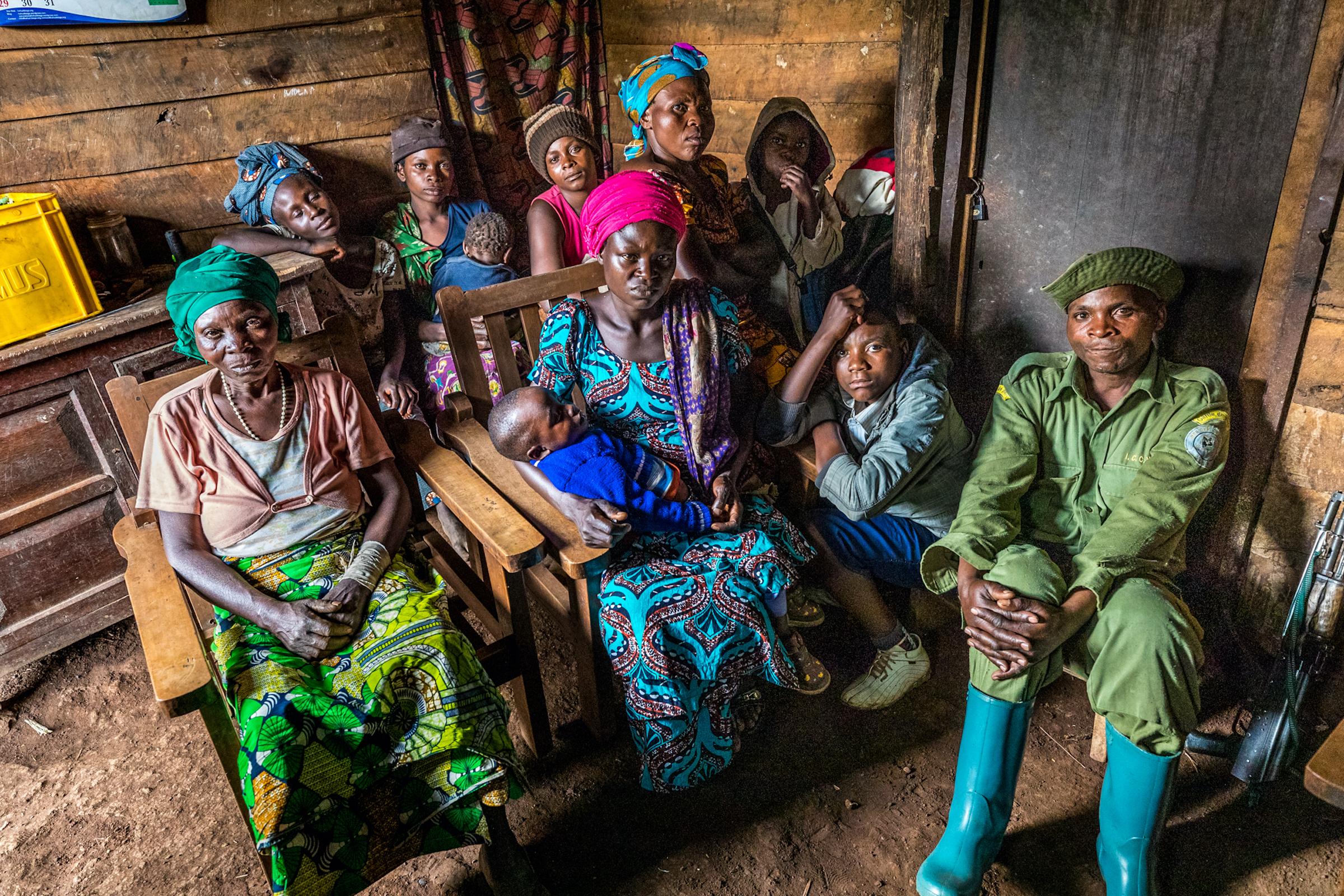 Oscar, a ranger at Kahuzi-Biega National Park, sits with his family and that of his father (also a ranger), who was killed in the park while on duty. by Marcus Westberg
