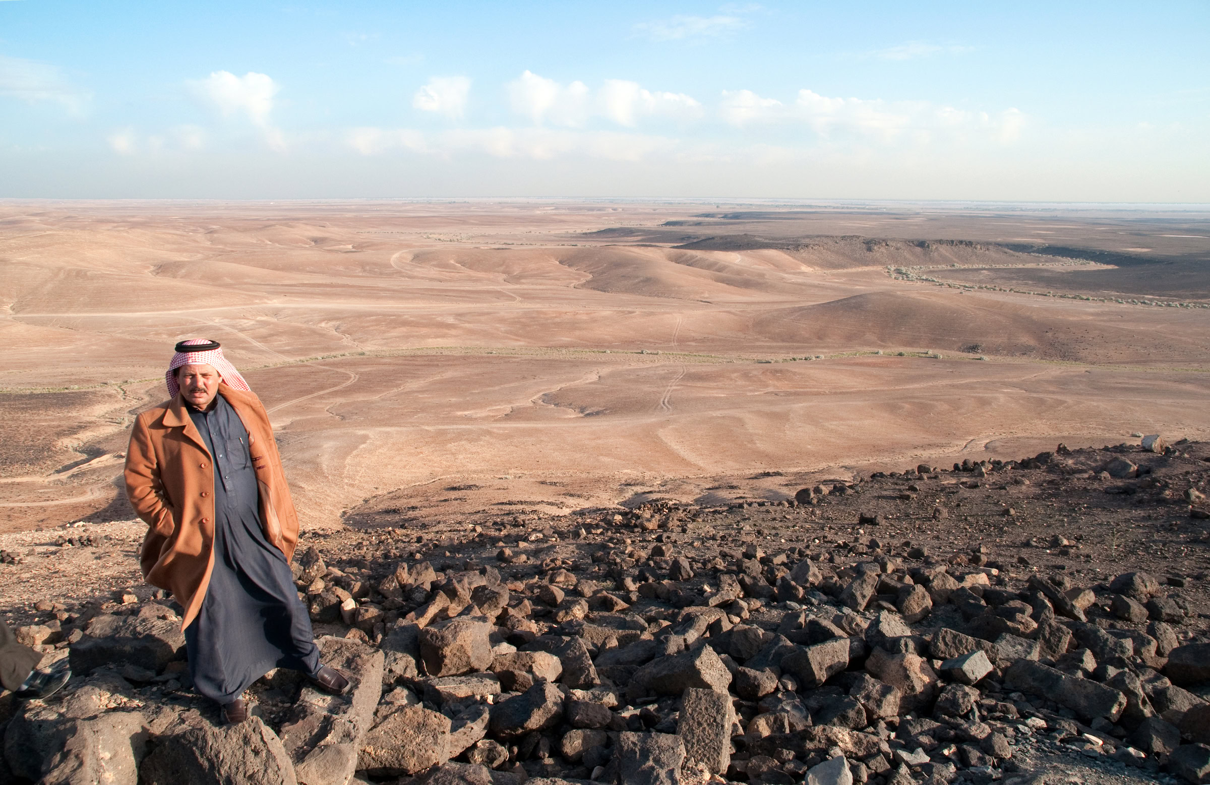 A Badia man visits the Nabatean ruins in Jordan’s Wadi Rum desert with the seemingly barren landscape in the background. Photograph by John Zada