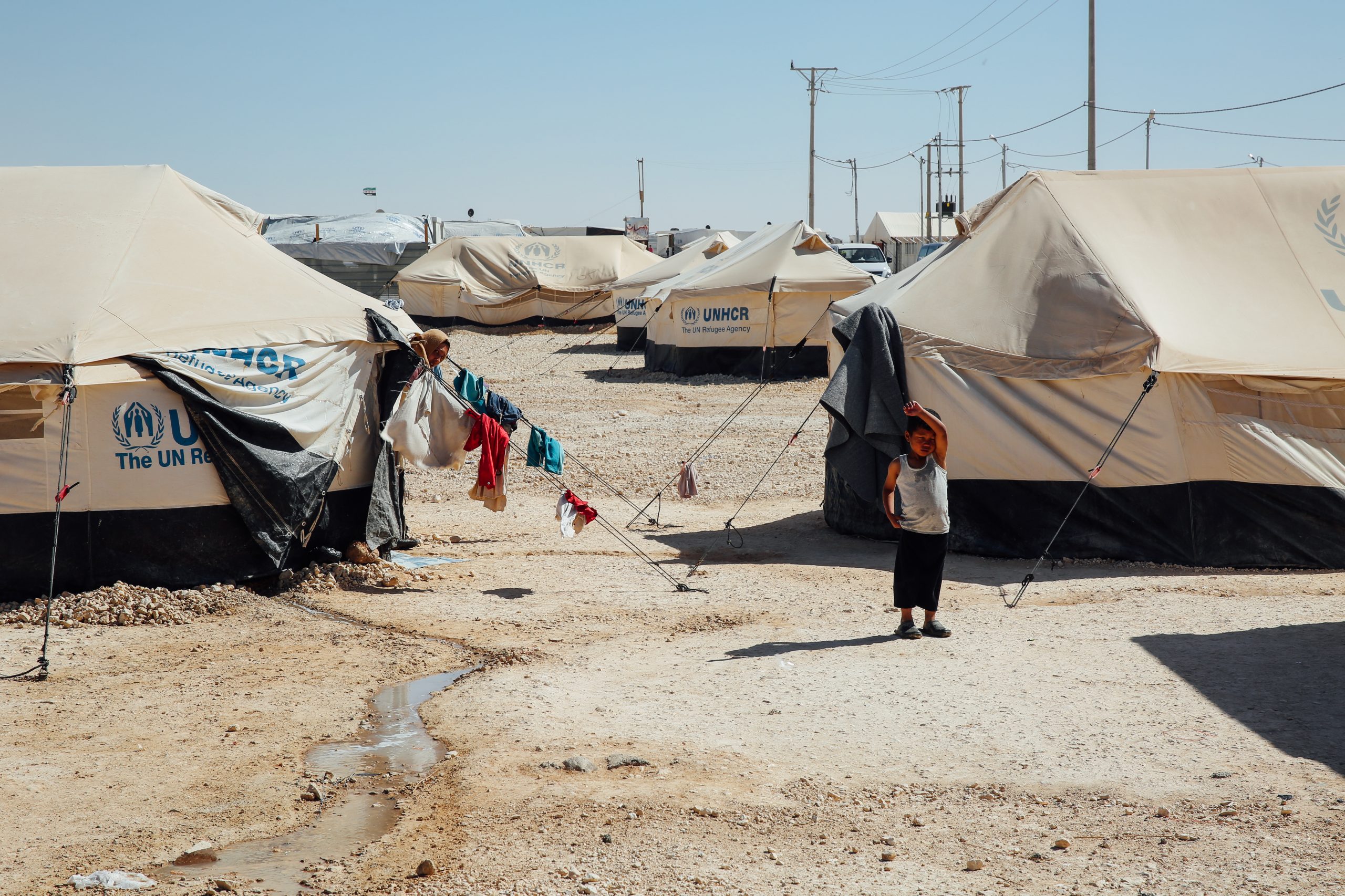More than one million refugees came to Jordan after the outbreak of civil war in Syria, with many temporarily housed in refugee camps across the country. This child stands in front of a UNHCR tent at the Zaatari Refugee camp in Mafraq, Jordan. Photograph by Ehab Mousa / Shutterstock