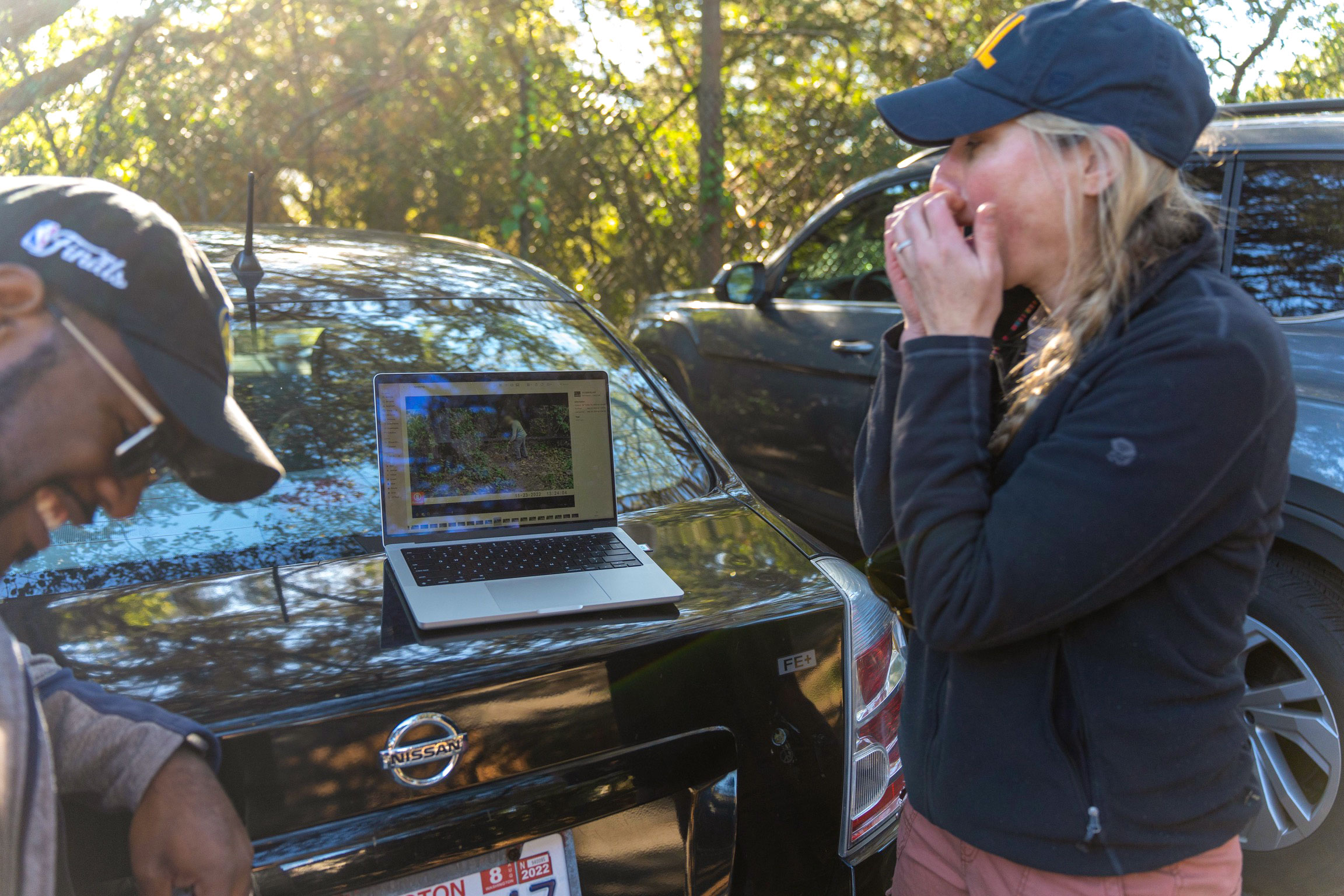Chris Schell and Lauren Stanton of the University of California, Berkeley, crack up while reviewing trail camera footage that shows a surprise animal disabling one of their puzzles—a human boy. Photograph by Betsy Mason