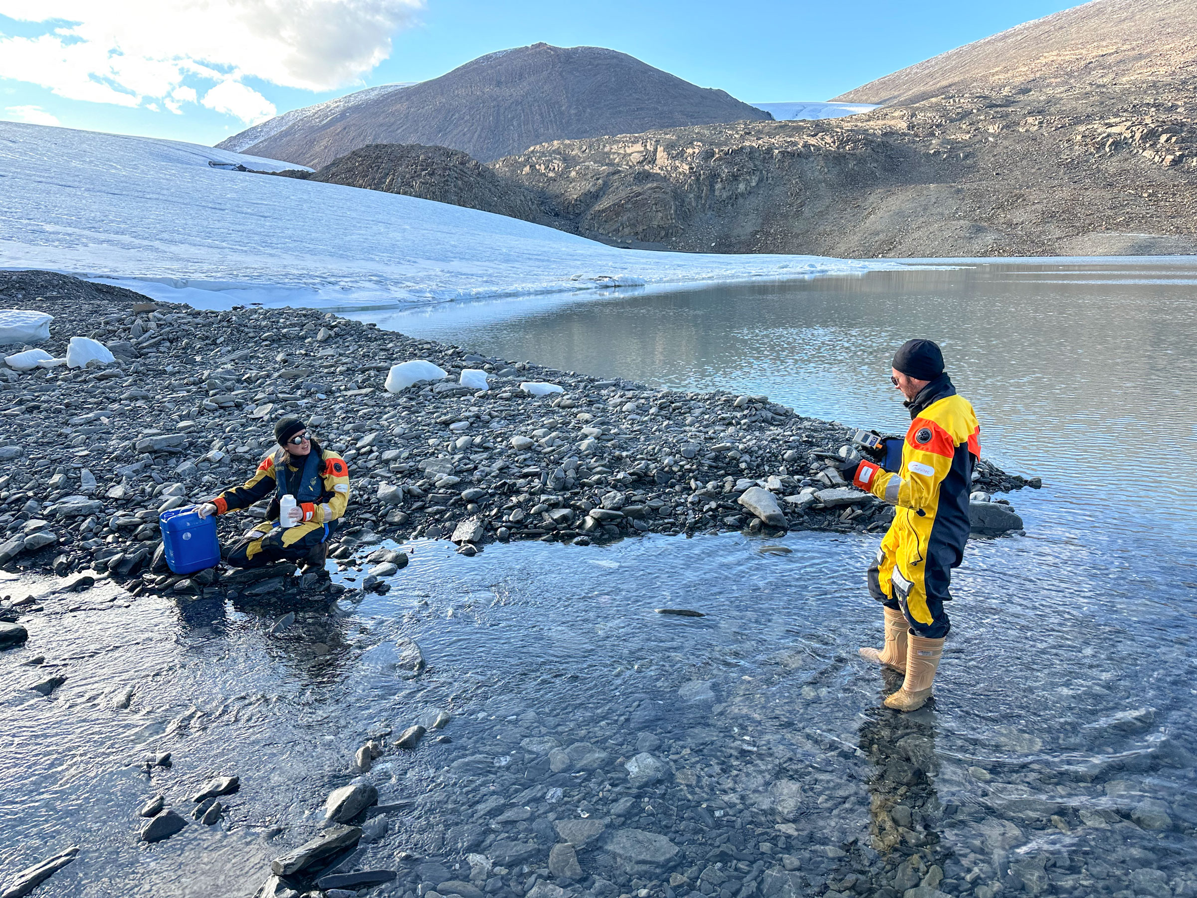 Mathieu Ardyna (right), and colleague Juliette Provencher (left) collect water samples near the outflow of a glacier near the Last Ice Area