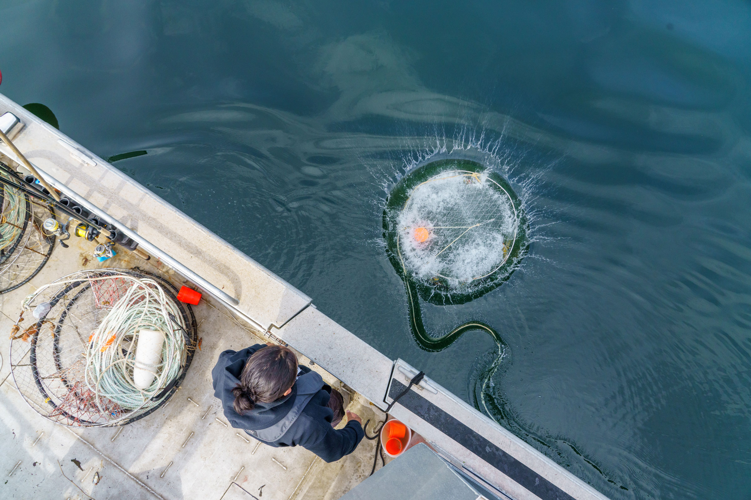 Nick Duncan throws a crab pot off the side of Ksm Wüts’iin.