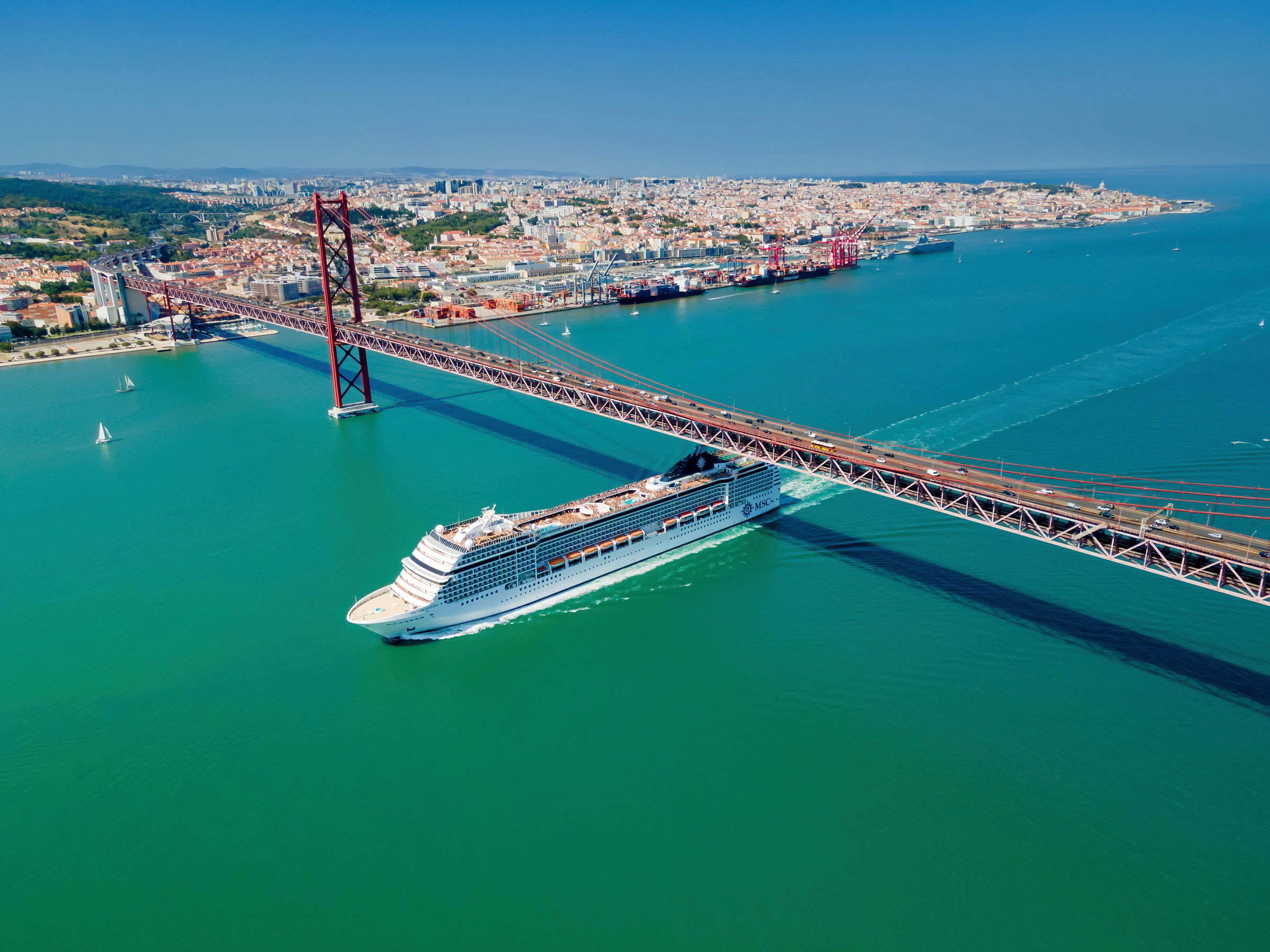 Cruise ship sails under a bridge on the Tagus River